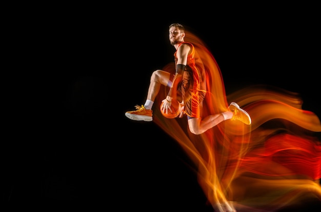 High flight. Young caucasian basketball player of red team in action