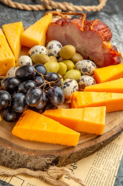 Free photo high resolution photo of best snack with various fruits and foods on a wooden brown tray rope on an old newspaper