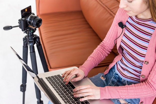 Free photo high view blogger sitting on the couch using her laptop