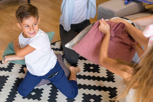 Free photo high view children playing with pillows