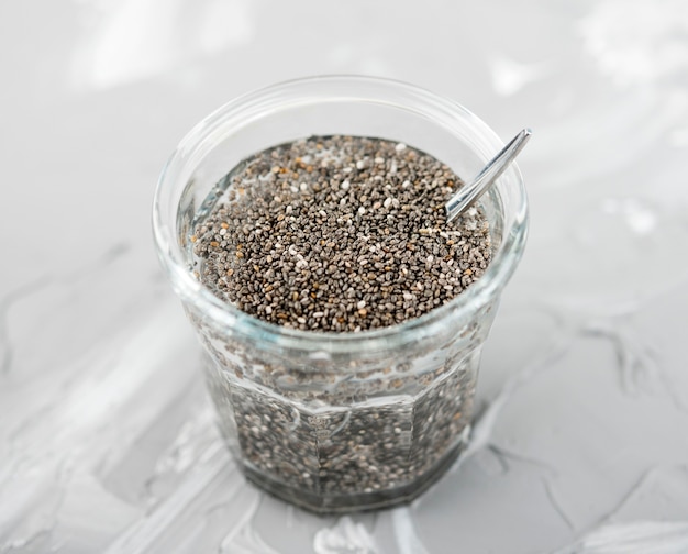 Free photo high view glass of natural seeds and spoon