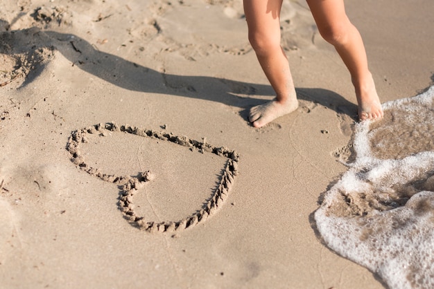 Free photo high view heart shape drawn in sand