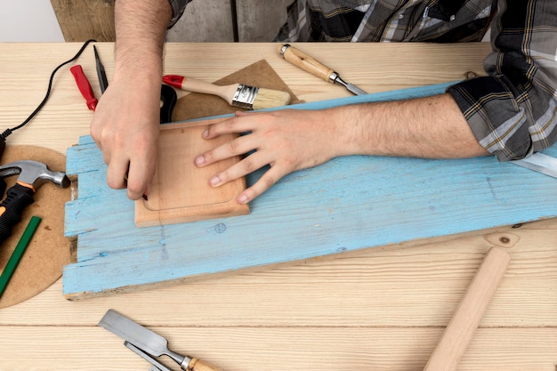 High view man using a pencil on wood