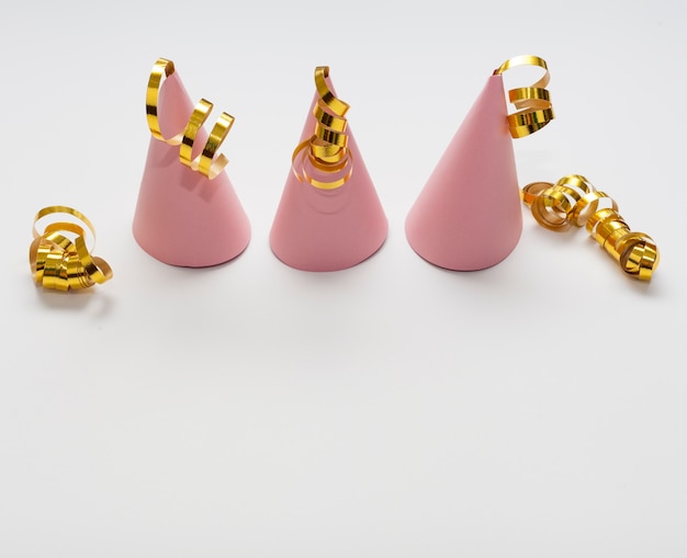 Free photo high view pink party hats with golden ribbons