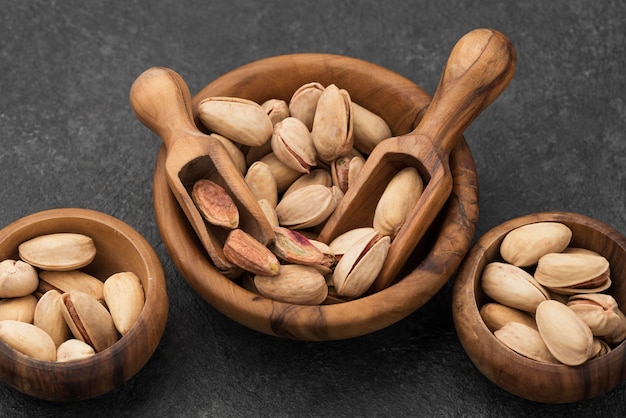 High view pistachio nuts in bowls with wooden spoons