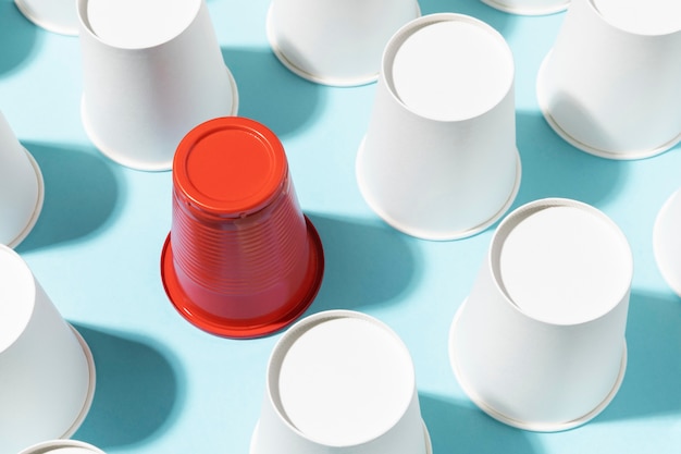 Free Photo high view red plastic cup surrounded by paper cups