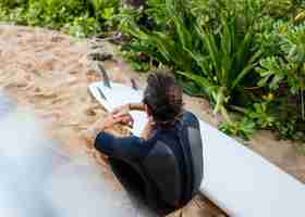 Free photo high view surfer and his surfboard