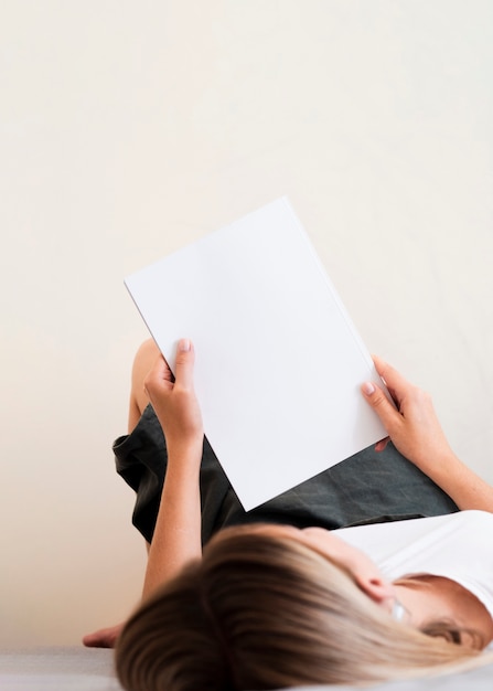 High view woman holding a mock-up magazine