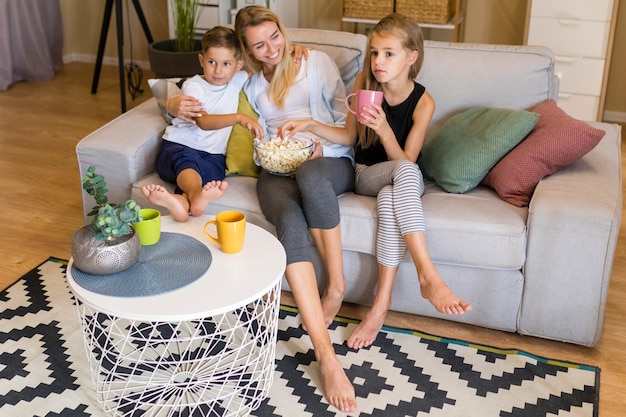 High view woman and kids eating popcorn