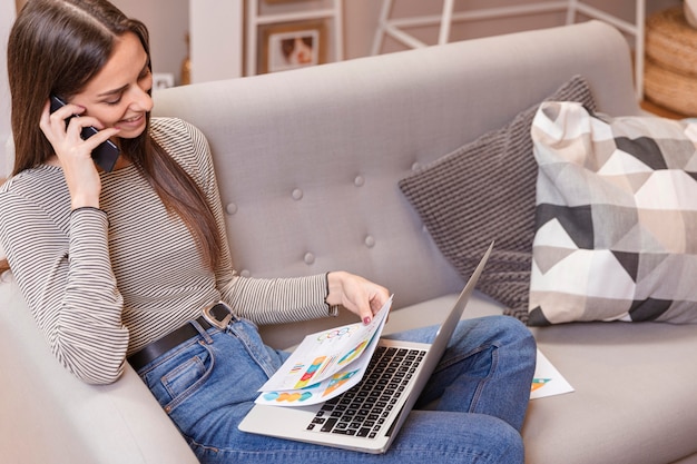 High view woman working from home and looking at charts