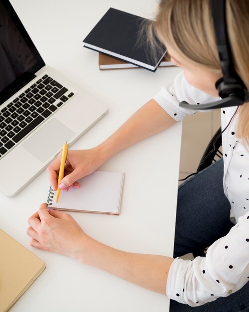 High view woman writing on a notepad