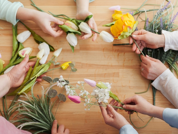 Free photo high view women hands with spring flowers