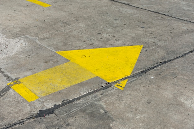 Free photo high view yellow painted arrow in the streets