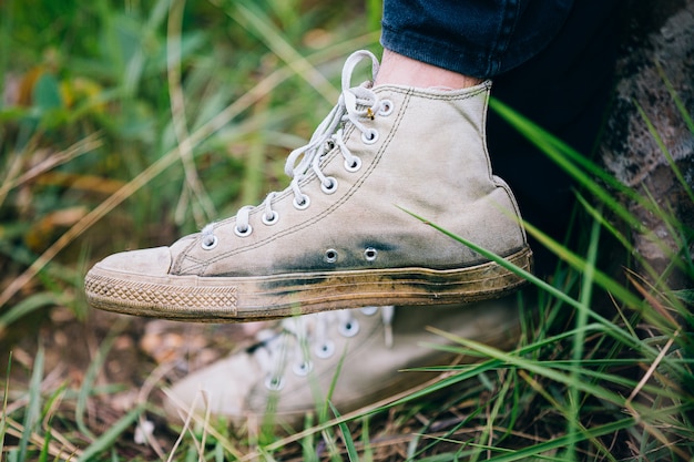 Free photo hiker man with trekking sticks climbs steep on mountain trail, focus on boot.