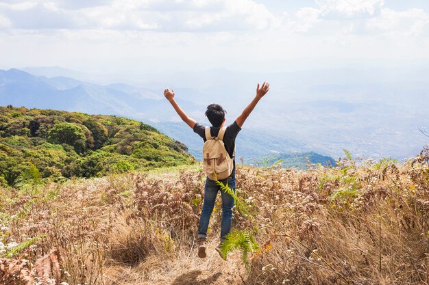 Hiker raising arms towards the sky