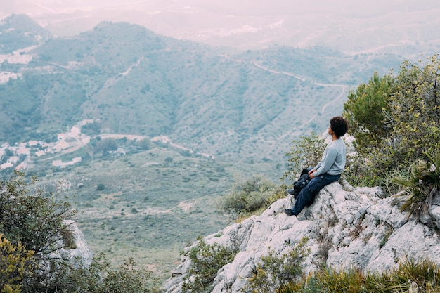 Free Photo hiker sitting on rock