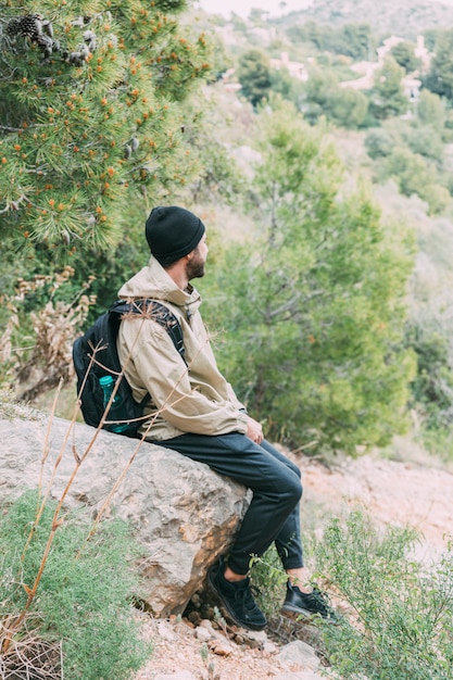 Free Photo hiker sitting on rock