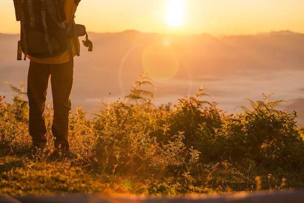 Free photo hiker stand at the camping near orange tent and backpack in the mountains