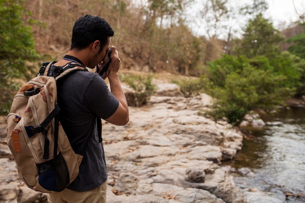 Free photo hiker taking photo of river