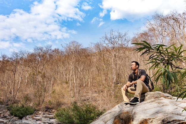 Free photo hiker taking a rest on a rock