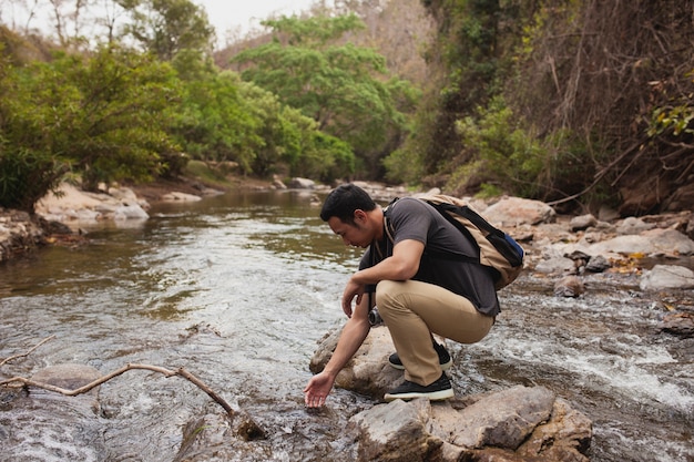 Free photo hiker touching water