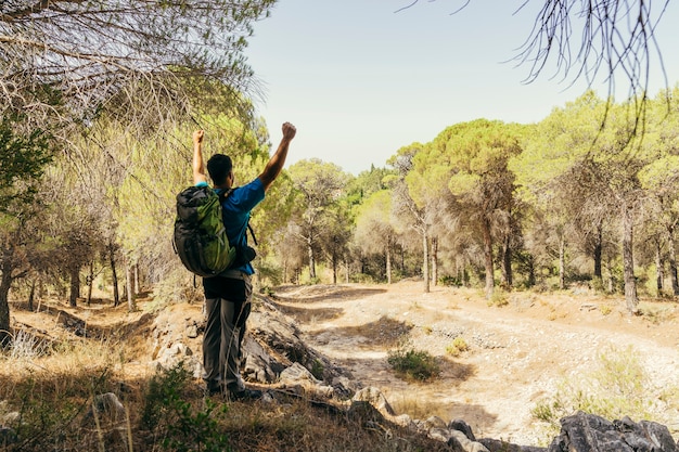 Free photo hiker with backpack raising fist