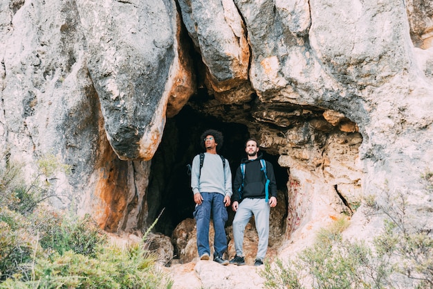 Free photo hikers in front of cave