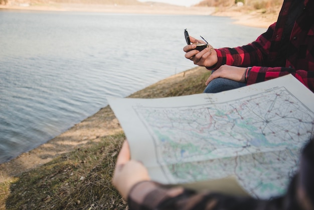 Hikers with map and compass by the lake