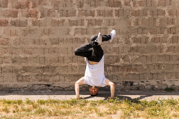 Hip hop acrobatic break dancer dancing against wall