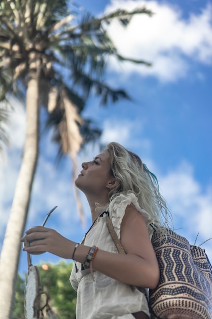 Free photo hippie girl with long blond hair in a dress on the roof.