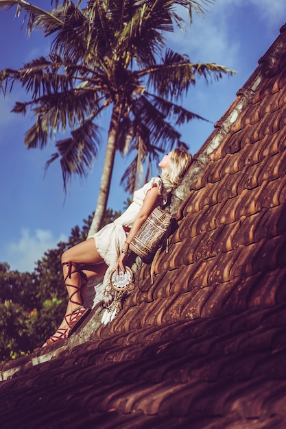 Free Photo hippie girl with long blond hair in a dress on the roof.