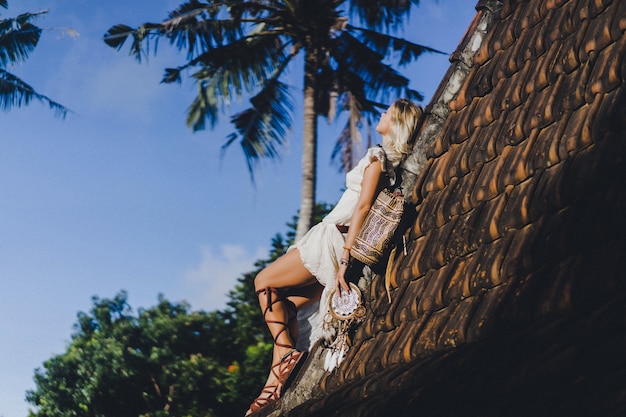 Free Photo hippie girl with long blond hair in a dress on the roof.