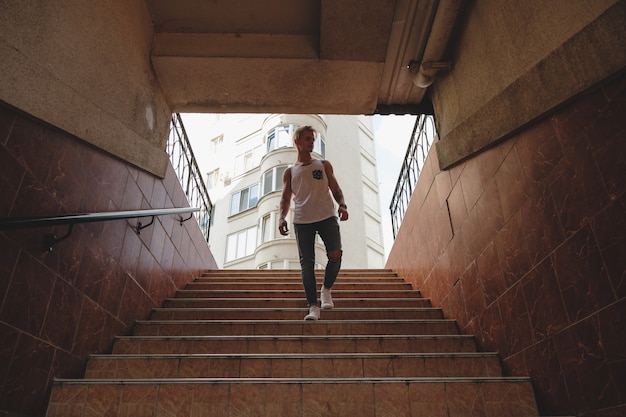 Hipster handsome blonde man guy in stylish summer clothes in the street