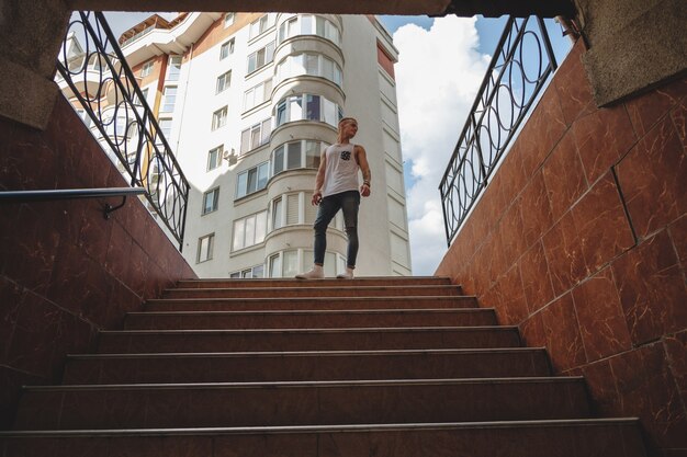 Hipster handsome blonde man guy in stylish summer clothes in the street