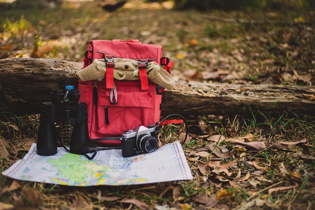 Free photo hipster red backpack and map in the forest