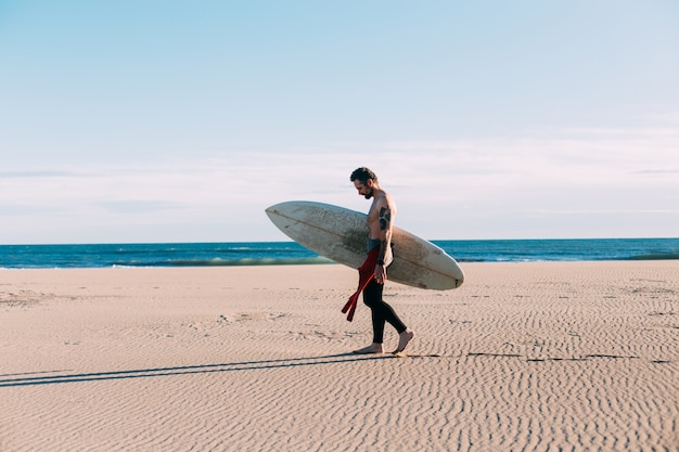 Free photo hipster trendy surfer on beach with surfboard