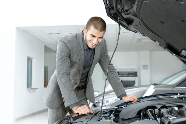 His new love Handsome guy in a suit checking a car before buying it