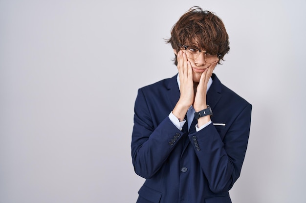 Hispanic business young man wearing glasses tired hands covering face, depression and sadness, upset and irritated for problem