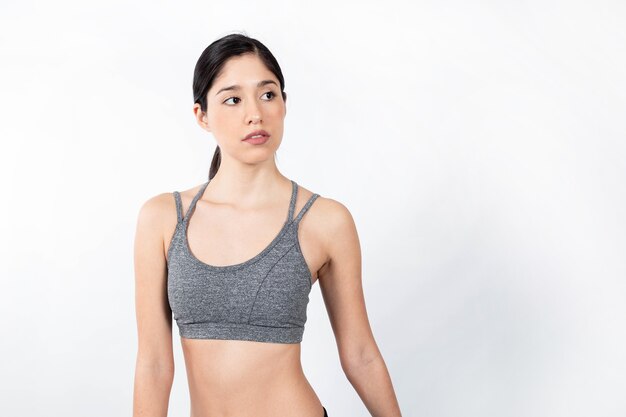 Hispanic female posing while wearing sportswear with a white background