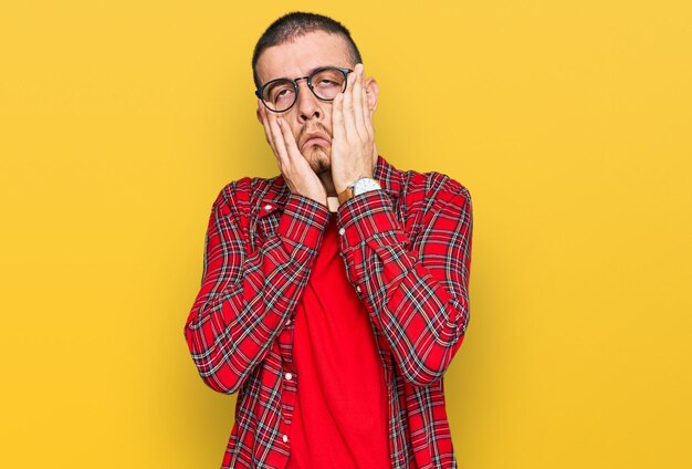 Hispanic young man wearing casual clothes tired hands covering face depression and sadness upset and irritated for problem