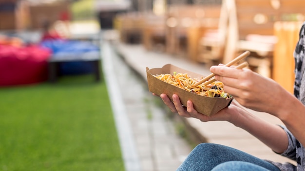 Free photo holding chinese food with blurred background