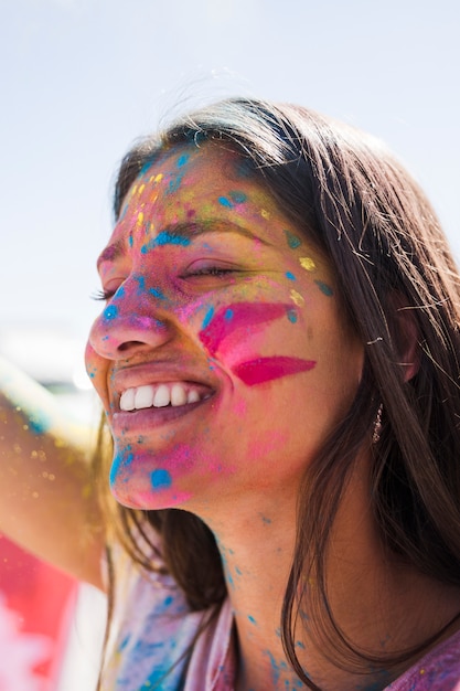 Free photo holi color over the smiling woman's face