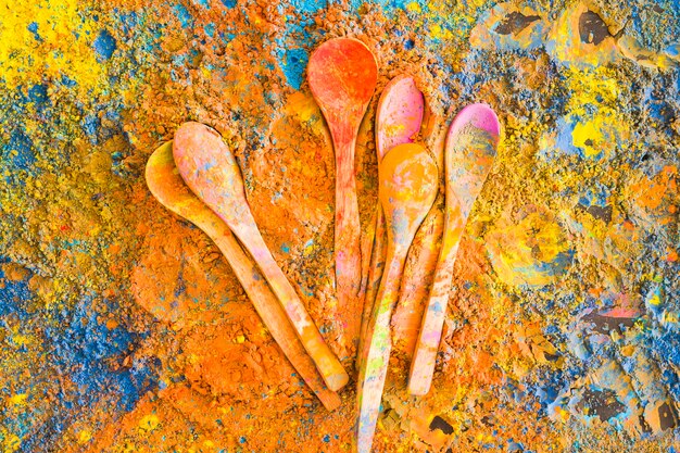 Holi powders splashed with wooden spoons