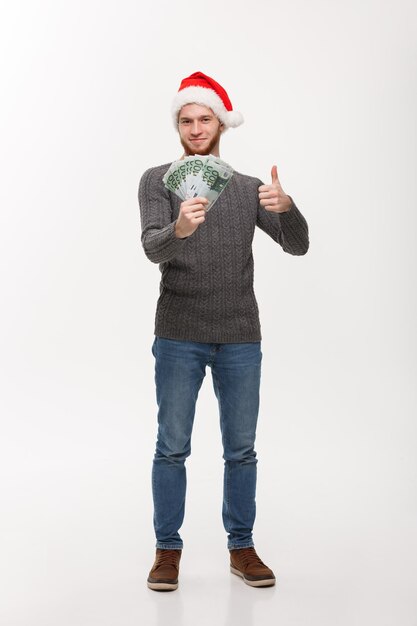 Holiday Concept young beard man holding money in front over white background