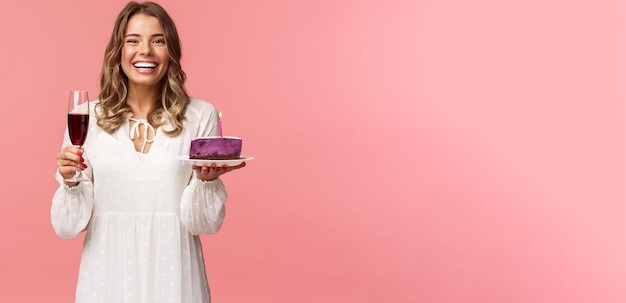 Free photo holidays spring and party concept portrait of excited goodlooking young tender girl celebrating birthday having fun with friends eating bday cake and drink wine from glass laughing joyfully