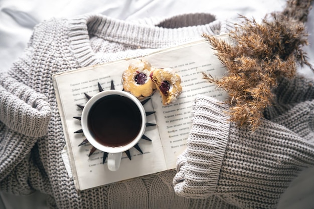 Free Photo home composition with a cup of coffee cookies a book and a knitted sweater