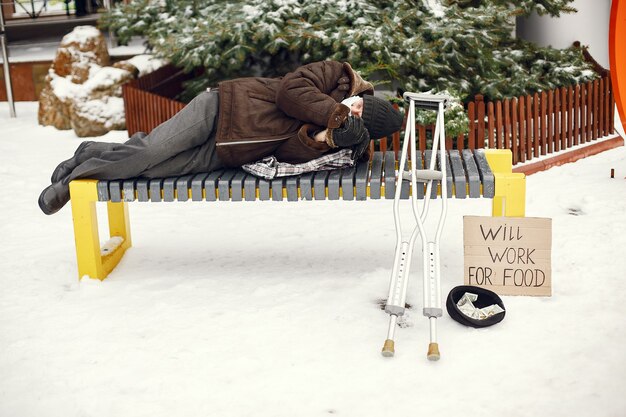 Homeless lying on a bench.