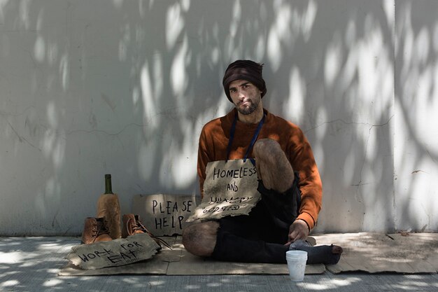 Free Photo homeless man with alcohol front view