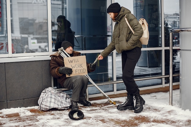 Homeless in a winter city. Man asking for food.