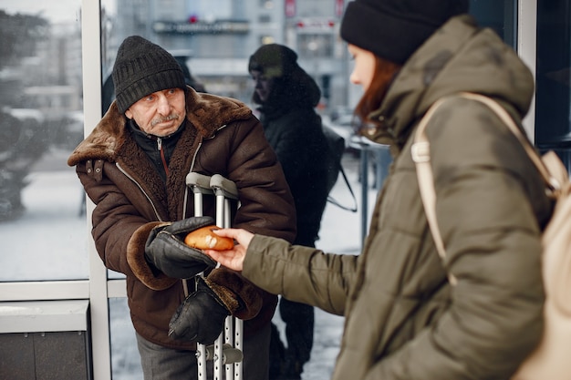 Free Photo homeless in a winter city. man asking for food.